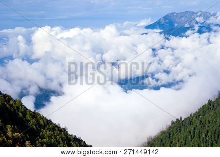 Landscape - View From The Mountain Top On A Sunny Day To The Valley Hidden By Low Clouds