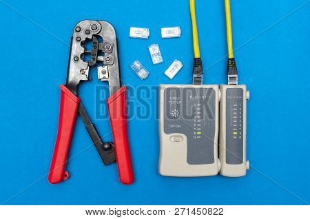 Cripmer Tool And Network Cable Tester Isolated On The Blue Background. Network Maitenance Background