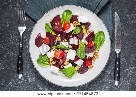 Dish With A Salad Of Feta, Beetroot, Cherry Tomatoes And Walnuts On A Stone Background. Top View