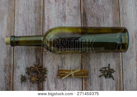 Hot Mulled Wine Drink With Lemon, Apple, Cinnamon, Anise And Other Spices In A Glass Cup Between Fir