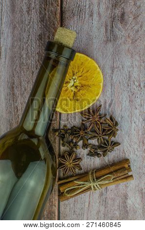 Hot Mulled Wine Drink With Lemon, Apple, Cinnamon, Anise And Other Spices In A Glass Cup Between Fir