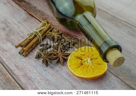 Hot Mulled Wine Drink With Lemon, Apple, Cinnamon, Anise And Other Spices In A Glass Cup Between Fir
