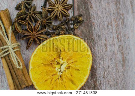 Hot Mulled Wine Drink With Lemon, Apple, Cinnamon, Anise And Other Spices In A Glass Cup Between Fir