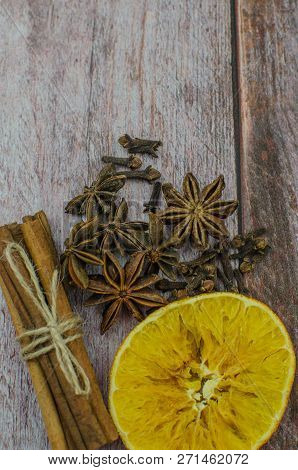 Hot Mulled Wine Drink With Lemon, Apple, Cinnamon, Anise And Other Spices In A Glass Cup Between Fir