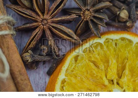 Hot Mulled Wine Drink With Lemon, Apple, Cinnamon, Anise And Other Spices In A Glass Cup Between Fir