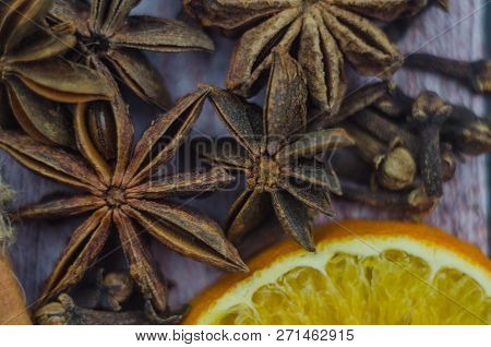 Hot Mulled Wine Drink With Lemon, Apple, Cinnamon, Anise And Other Spices In A Glass Cup Between Fir