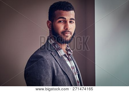 African-american Young Man Looking At A Camera In A Studio.