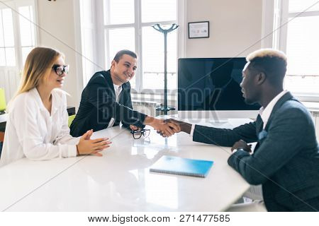 Afro American Investment Advisor Shaking Hands With Smiling Man While Consulting With Young Couple A