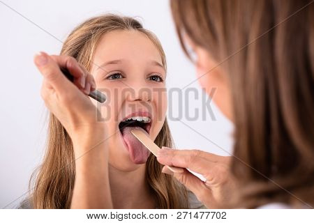 Doctor Checking Girl's Sore Throat