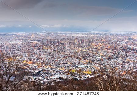 Sapporo, Japan winter skyline view from the mountains at dusk.