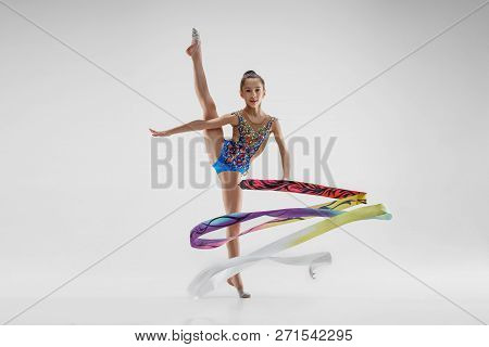 The Portrait Of Beautiful Young Brunette Woman Gymnast Training Calilisthenics Exercise With Blue Ri