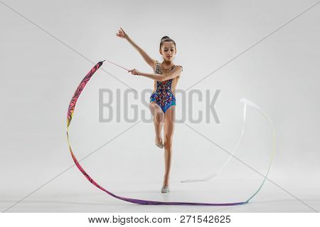 The Portrait Of Beautiful Young Brunette Woman Gymnast Training Calilisthenics Exercise With Blue Ri