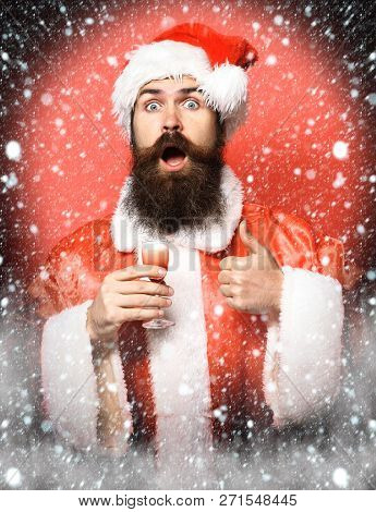 Handsome Bearded Santa Claus Man With Long Beard On Surprisedface Holding Glass Of Alcoholic Shot In