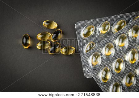 Fish Oil Omega3 Capsules And Blister Biologically Active Additive On A Dark Background Close-up Top 