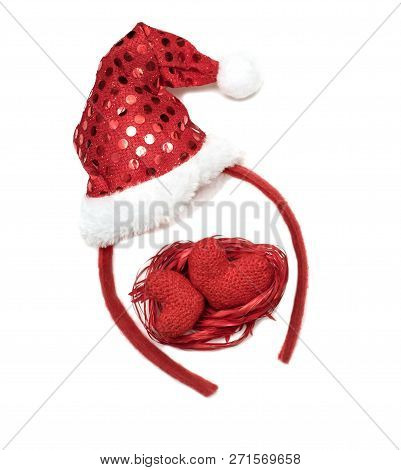 Christmas Decoration With A Red Cap Of Santa Claus And Two Hearts On White