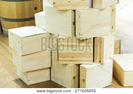 Wooden Boxes For Bottles Of Wine In Wineshop. Floor And Barrel On The Background.