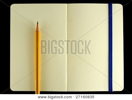 Classic opened moleskine note book with pencil isolated on black background
