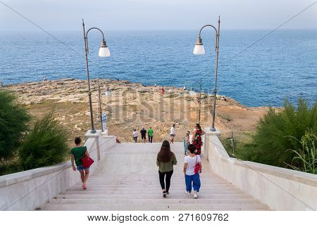 Polignano A Mare, Italy - July 6 2018: Tourist On Stairs Leading To Dramatic Cliffs Over Adriatic Se
