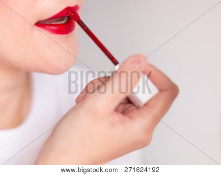 Close-up Image Of Woman Dyes Her Lips With Red Lipstick; Selective Focus At Her Lips.