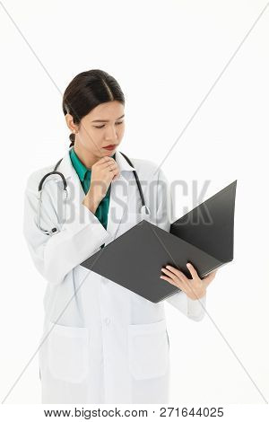 Asian Female Docter Is Working On Patient File. In Uniform And Astethoscope On Shoulder, Isolated In