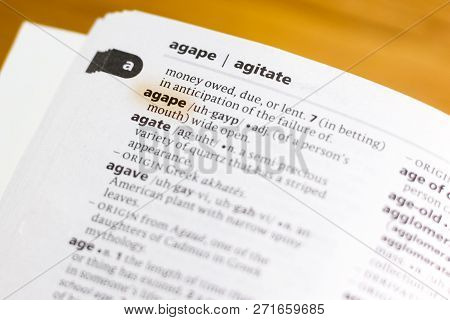 The Word Or Phrase Agape In A Dictionary Highlighted With Marker.