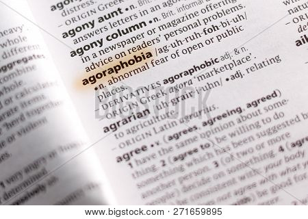 The Word Or Phrase Agoraphobia In A Dictionary Highlighted With Marker.