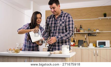 Happy Young Couple Have Fun In Modern Kitchen Indoor While Preparing