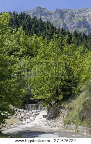 Problems On The Road. Rural, Narrow Road Damaged By A River Flowing Through It In Summer.