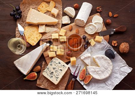 Variety Of Different Cheese With Wine, Fruits And Nuts. Camembert, Goat Cheese, Roquefort, Gorgonzol
