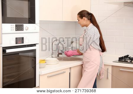 Woman Doing Washing Up In Kitchen. Cleaning Chores