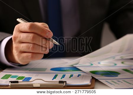 Male Hand In Suit Hold Siver Pen In Office With Clipboard On Table Closeup. Comprehensive Audit Of E