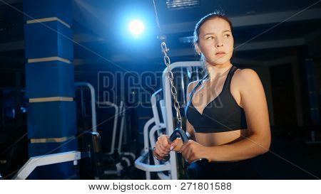 The Girl Performs The Extension Of The Arms For The Triceps In A Block Simulator.