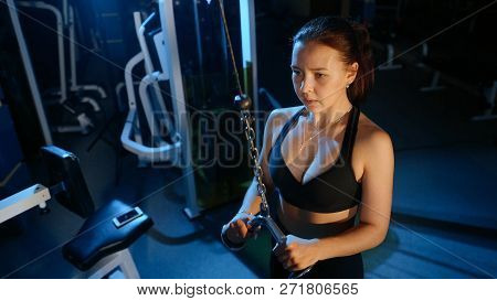The Girl Performs The Extension Of The Arms For The Triceps In A Block Simulator.