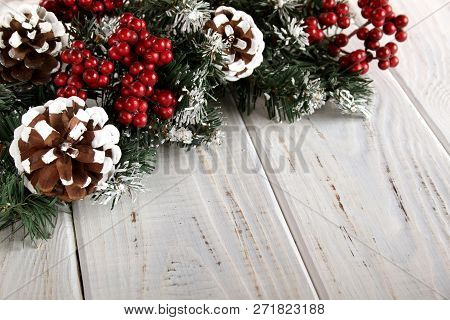Spruce Branches, Cones And Red Berries On A White Wooden Background. Background For Christmas And Ne