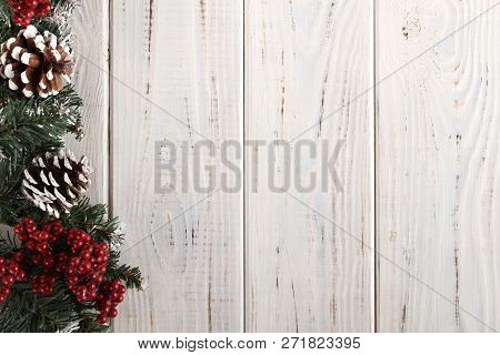 Spruce Branches, Cones And Red Berries On A White Wooden Background. Background For Christmas And Ne