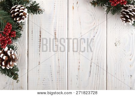 Spruce Branches, Cones And Red Berries On A White Wooden Background. Background For Christmas And Ne