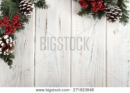 Spruce Branches, Cones And Red Berries On A White Wooden Background. Background For Christmas And Ne