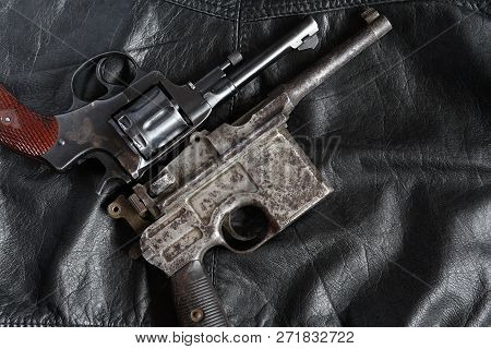 Old Revolver And Pistol Closeup On Dark Leather Background