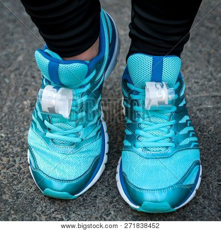 Cyan Running Shoes On A Woman Feet With Two Sensors Affixed Before Running Competition Start