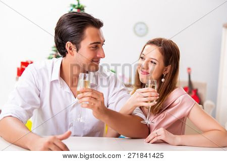 Young couple celebraring christmas with champagne