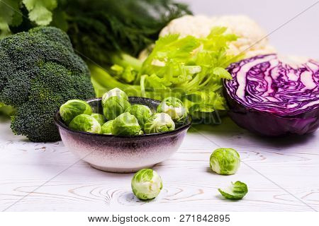 Close-up Of Assorted Fresh Vegetables On A Black Slate On A Wooden Table: Cabbage, Broccoli, Caulifl