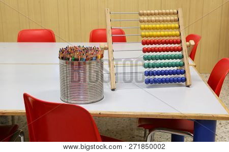 Table With Wooden Abacus And A Jar Full Of Colored Pencils In The Classroom Of The School