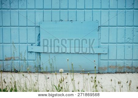 Blue Hatchway In Wall Of Building Close Up With Copy Space. Background Of Cyan Closed Hatch On Tiles