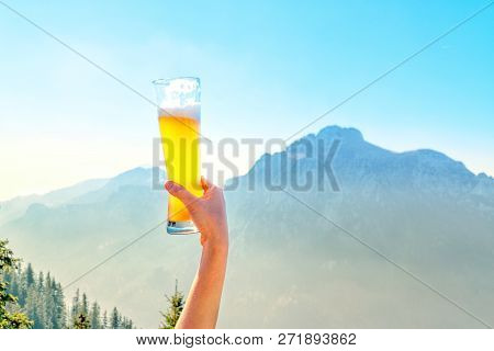 Hands Lifting Draft Beer Glass And Happy Enjoying Harvest Time At Outdoor On Beautiful Mountain Scen