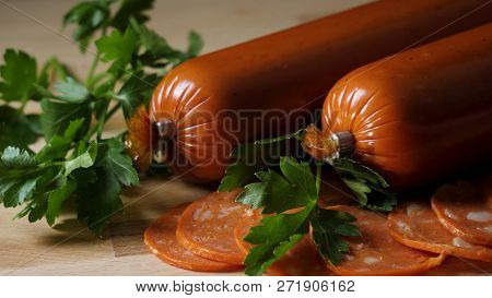 Dried Organic Salami Sausage On Wooden Cutting Board. Frame. Sausage On A Wooden Board With Rosemary