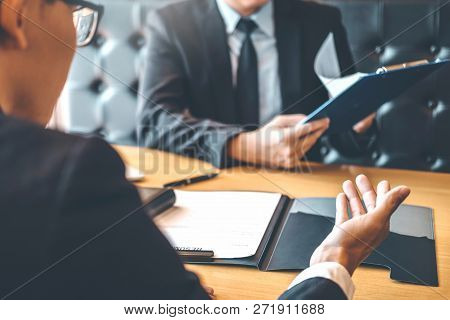 Senior Manager Reading A Resume During A Job Interview Employee Young Man Meeting Applicant And Recr