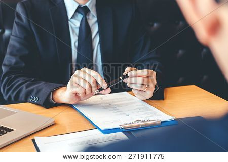 Senior Manager Reading A Resume During A Job Interview Employee Young Man Meeting Applicant And Recr