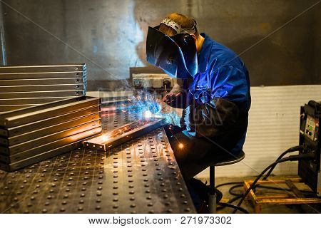 Working Welder Welds The Parts. A Process Using A Semi-automatic Welding.