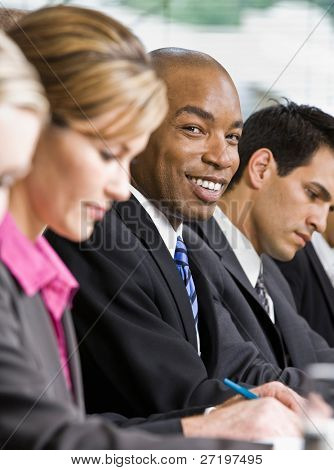 เพื่อนร่วมงาน multi-ethnic ที่นั่งในแถว