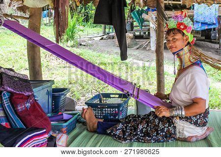 Chiang Rai, Thailand - July 25, 2011: A Padang Kayan Tribe Girl With Her Loom Dressed With The Typic